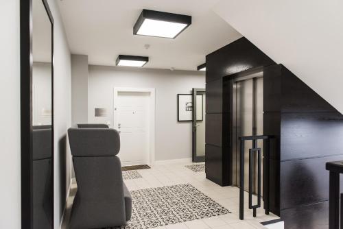 - un couloir avec une chambre noire et blanche avec un escalier dans l'établissement Harmonica Home by LoftAffair, à Cracovie