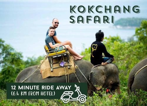 two people riding on the back of an elephant at Phoenix Hotel Karon Beach in Karon Beach