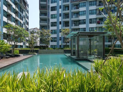 a swimming pool in front of a building at 2 Floor - Centrio Condominium near Central Shopping Mall and Phuket Old town in Phuket