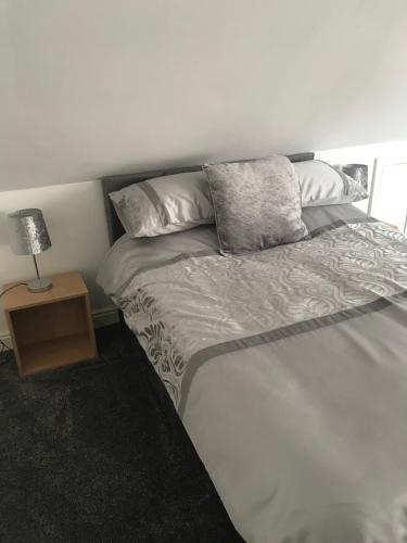 a bed with two pillows and a night stand at The Bungalow in Leeds
