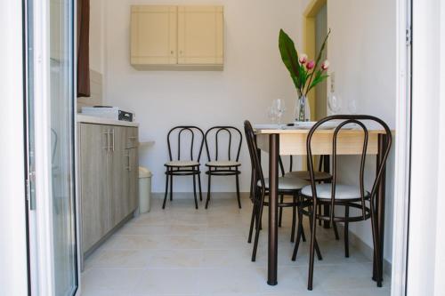 uma cozinha com mesa e cadeiras num quarto em KELLY APARTMENTS em Ýpsos