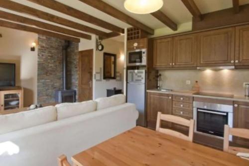 a living room with a white couch in a kitchen at Peace & Rest in Pirineus in Latour-de-Carol