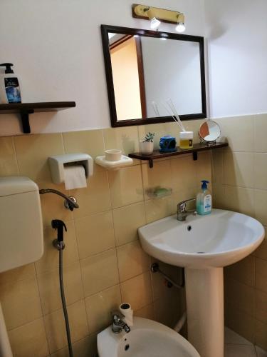 a bathroom with a sink and a toilet and a mirror at Holiday Home Zolfare in Comitini