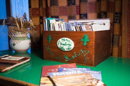 a wooden box sitting on a table with books at The Flowers' House in Potenza