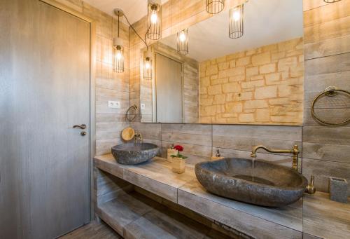 two sinks in a bathroom with two mirrors at Villa Sirocos in Stalos