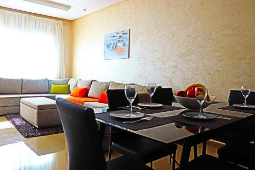 a dining room with a table and a couch at Appartement Standing Quartier Tour Hassane (près Marina) in Rabat
