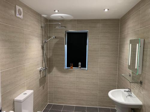 a bathroom with a sink and a toilet and a window at sark house Apartment Chorlton manchester in Manchester