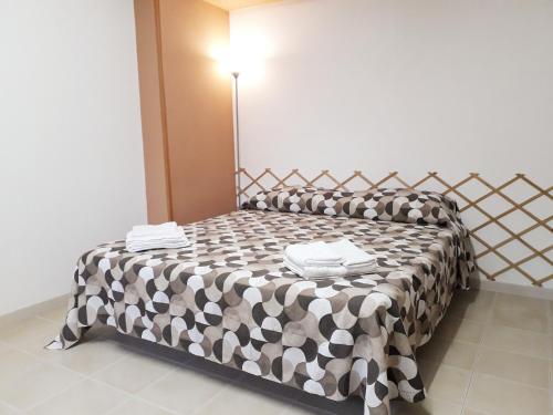 a bedroom with a bed with a black and white blanket at Liberty House in Marsala