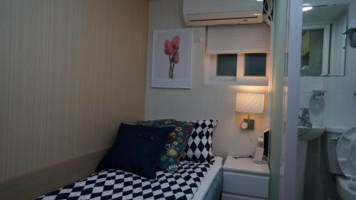 首爾的住宿－Guest House ShaSha，小房间设有床和水槽