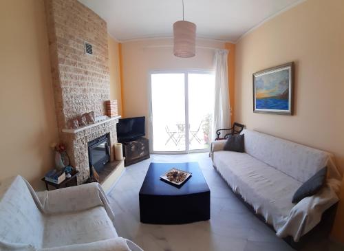a living room with a couch and a fireplace at Apartment Michalis by the Sea in Artemida