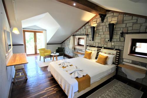 a bedroom with a large bed and a stone wall at Dalyan Villa StoneHouse-2 in Dalyan