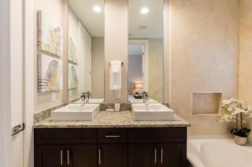 a bathroom with two sinks and a large mirror at Summerville Vacation Resort in Orlando