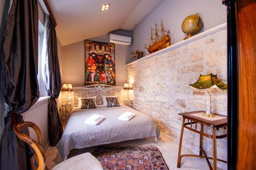 a bedroom with a bed and a stone wall at Villa Shiraz in Selca
