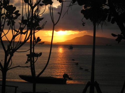 a sunset over the ocean with boats in the water at Davina Beach Homes in Panwa Beach
