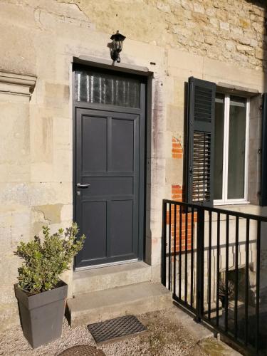 une porte noire sur le côté d'un bâtiment dans l'établissement À tire-larigot, à Cousances-aux-Forges