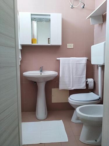 a pink bathroom with a sink and a toilet at La Nassa Salento in Casalabate