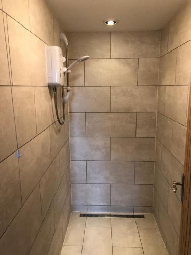 a bathroom with a shower with tiled walls at The Barn in Wyboston
