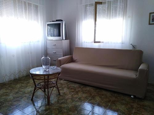 un soggiorno con divano, tavolo e TV di La Nassa Salento a Casalabate
