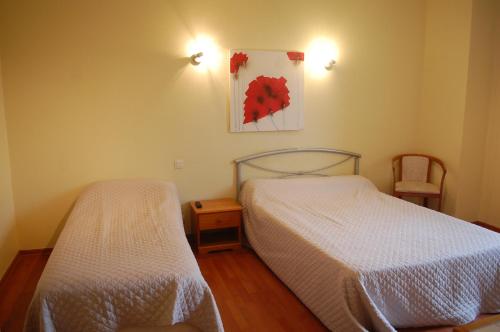 a bedroom with two beds and a picture on the wall at Chateau de Faudade in Lévignac-sur-Save