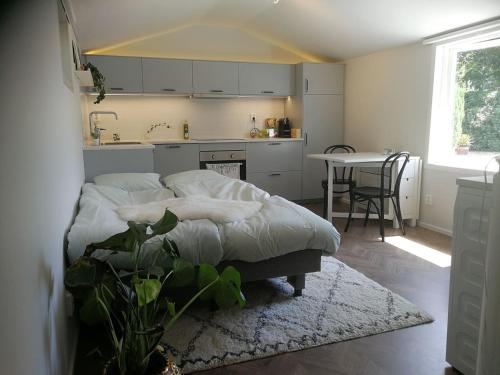 um quarto com uma cama e uma cozinha com uma mesa em Hytten Skanör em Skanör med Falsterbo