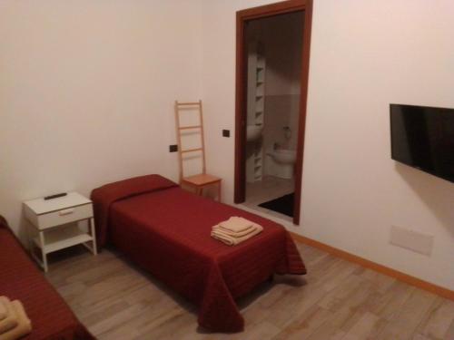 ein kleines Schlafzimmer mit einem roten Bett und einem Spiegel in der Unterkunft Al terminal in Somma Lombardo