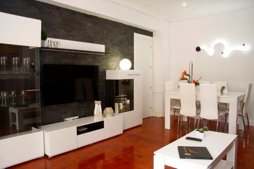 Una sala de estar con un televisor grande y una mesa. en Princesa VUT, en Cuenca