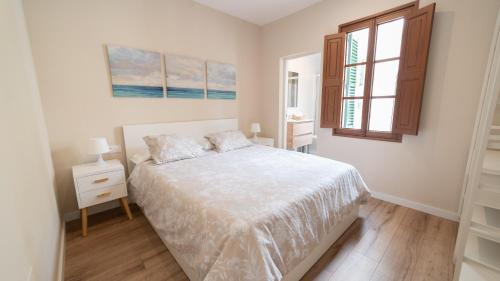 a white bedroom with a bed and a window at City Center Palma in Palma de Mallorca