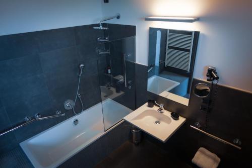 a bathroom with a sink and a shower and a tub at Hotel Lungomare in Cesenatico