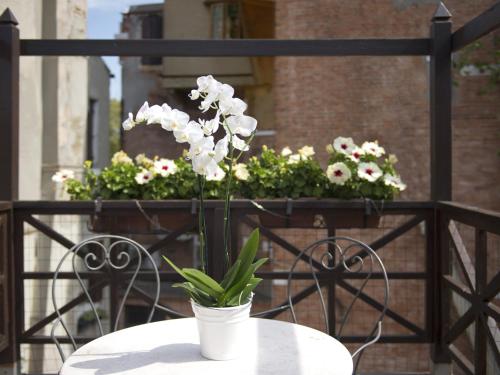 a white table with a potted plant on a balcony at Hotel Campiello in Venice