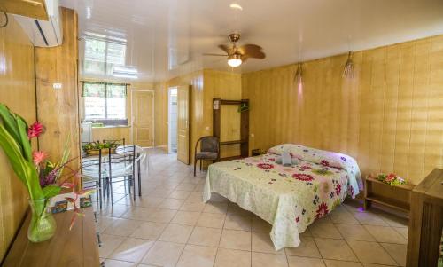 a bedroom with a bed and a table in a room at Fare Ara Location Huahine in Fare