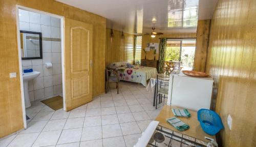 um quarto com uma cozinha e uma casa de banho com uma mesa em Fare Ara Location Huahine em Fare
