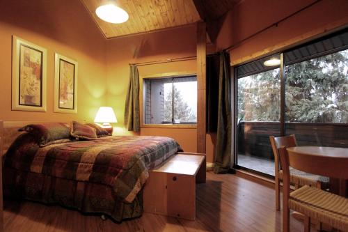 um quarto com uma cama, uma mesa e uma janela em Rainbow Suites by Whistler Retreats em Whistler