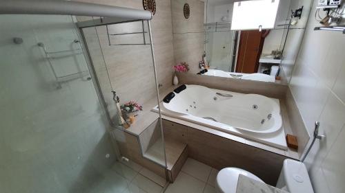 a bathroom with a bath tub and a sink at Condomínio Raízes Marina in Salinópolis