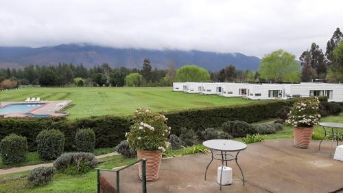 a garden with a table and a pool and a building at Achibueno Lodge in Linares