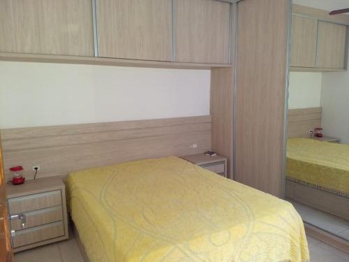 a bedroom with a yellow bed and two cabinets at Casa de Praia in Governador Celso Ramos