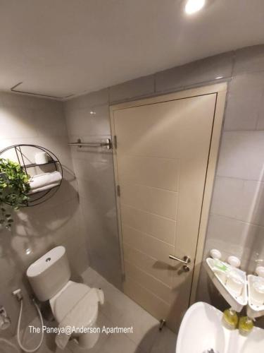 a bathroom with a shower and a toilet and a sink at The Paneya@Anderson Apartment in Surabaya