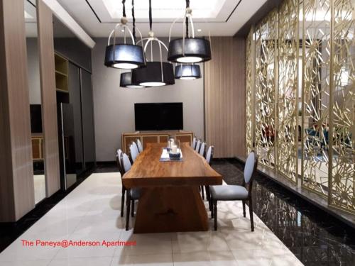 a dining room with a wooden table and chairs at The Paneya@Anderson Apartment in Surabaya