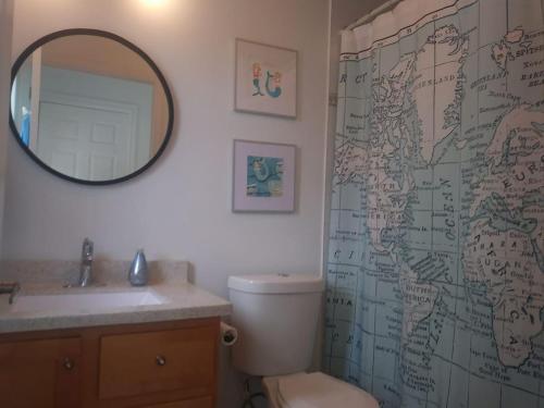 y baño con aseo, lavabo y espejo. en Private Waterfront Luxury on the Bras D'Or Lake, en Sydney Forks