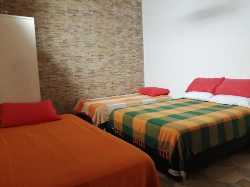 a room with two beds and a brick wall at Granados in Asuncion