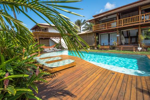 a house with a wooden deck and a swimming pool at Sup House Barra Grande in Barra Grande