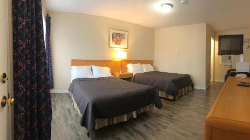 En eller flere senge i et værelse på Guest Inn Motel