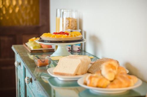a table topped with plates of bread and pastries at Hotel Boutique Cutipay in Valdivia