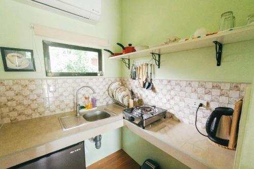 a small kitchen with a sink and a stove at The Three Shooting Stars in Panglao Island