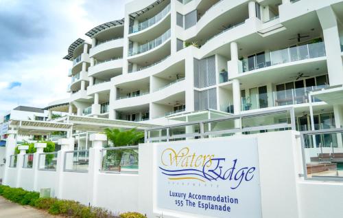 a hotel room with a large white building behind it at Waters Edge Apartment Cairns in Cairns