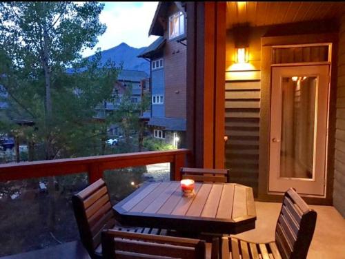 a wooden table and chairs on a porch with a window at Luxurious & Spacious Mountain Retreat in Canmore