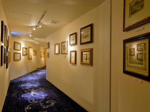 a hallway with pictures on the walls of a museum at Hotel Palm Royal Resort Kokusai Street in Naha
