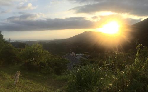 a view of the sun setting over a mountain at Kumano Winery Guest House in Tanabe