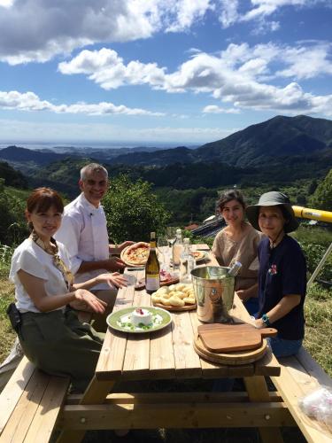 a group of people sitting around a picnic table at Kumano Winery Guest House in Tanabe
