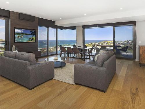 a living room with two couches and a view of the ocean at Cosmopolitan at SoHo in Gerringong