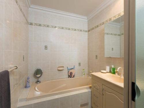 a bathroom with a tub and a sink and a dog on the wall at Coastal Haven at Gerroa in Gerroa